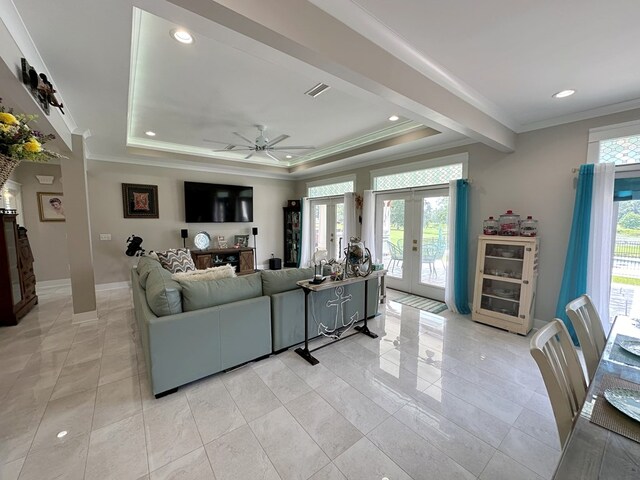 living room with french doors, a raised ceiling, ceiling fan, and crown molding