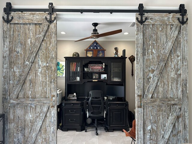 office space featuring ceiling fan and a barn door