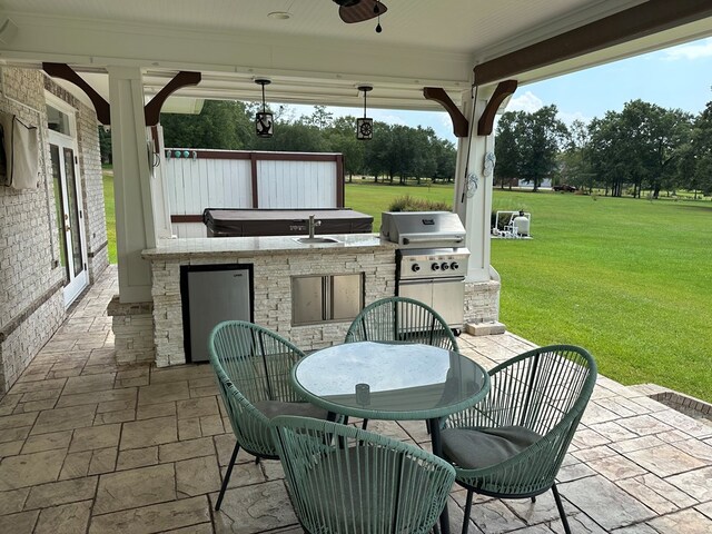 view of patio featuring ceiling fan, exterior kitchen, sink, and grilling area