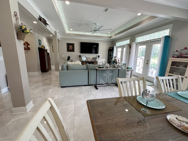 dining room featuring a raised ceiling, ceiling fan, french doors, and crown molding