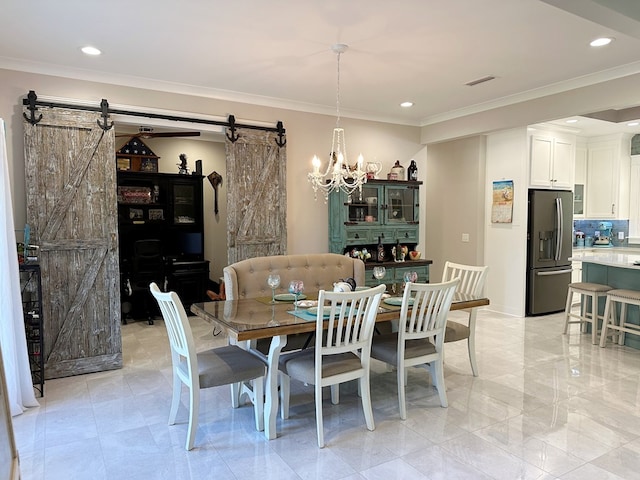 dining area with a chandelier, a barn door, and ornamental molding