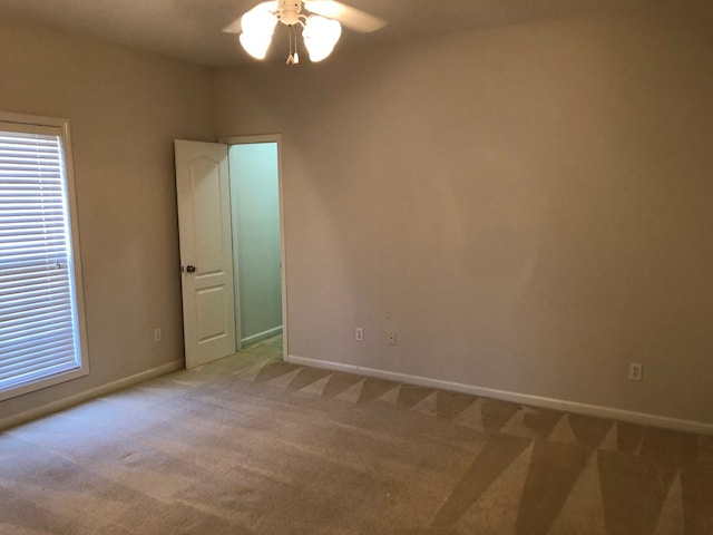 spare room featuring light carpet and ceiling fan