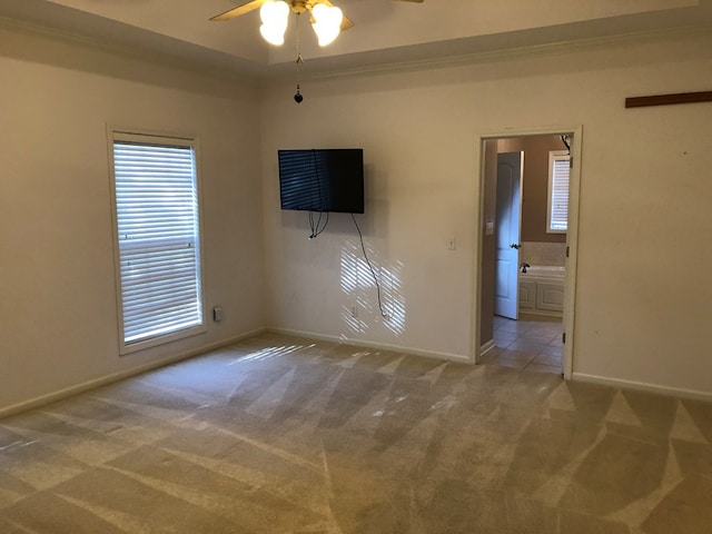 carpeted empty room featuring ceiling fan and crown molding