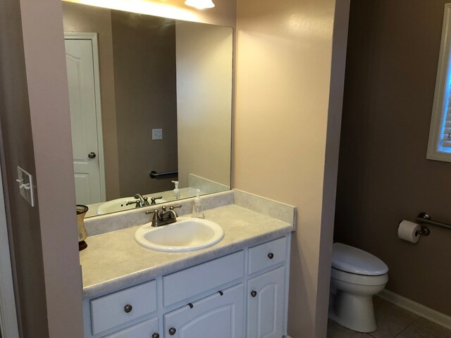 bathroom featuring tile patterned flooring, vanity, and toilet