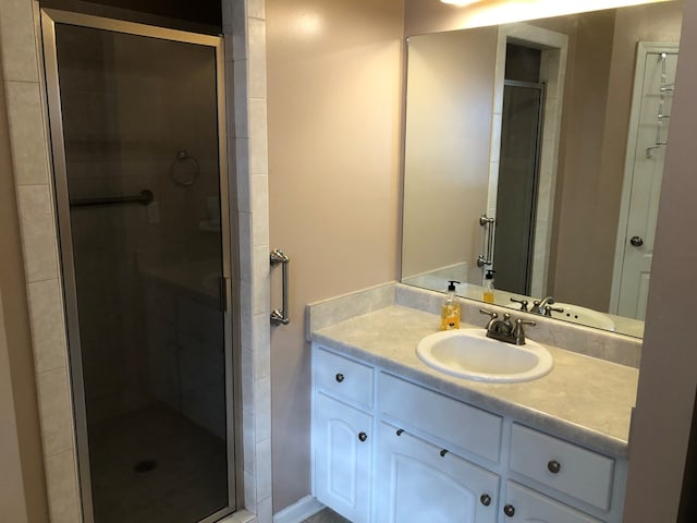 bathroom featuring vanity and a shower with shower door