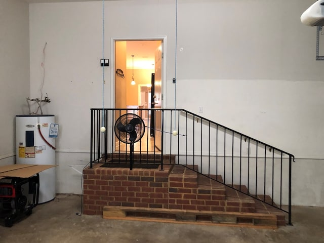 stairway with concrete flooring and water heater