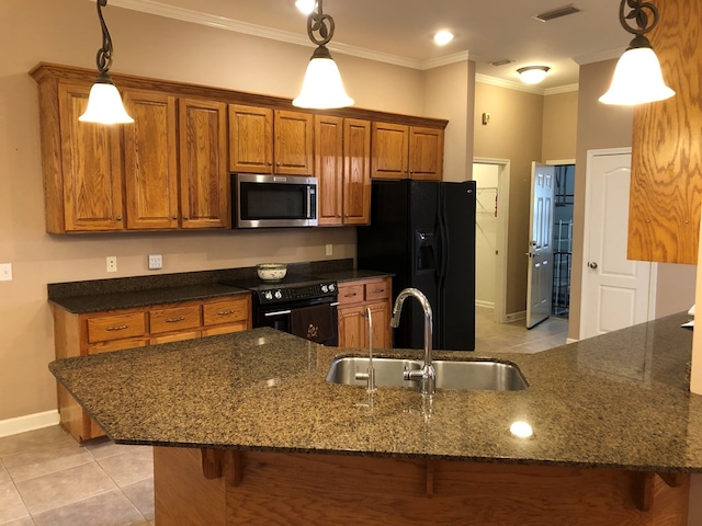 kitchen featuring black appliances, dark stone countertops, sink, and hanging light fixtures