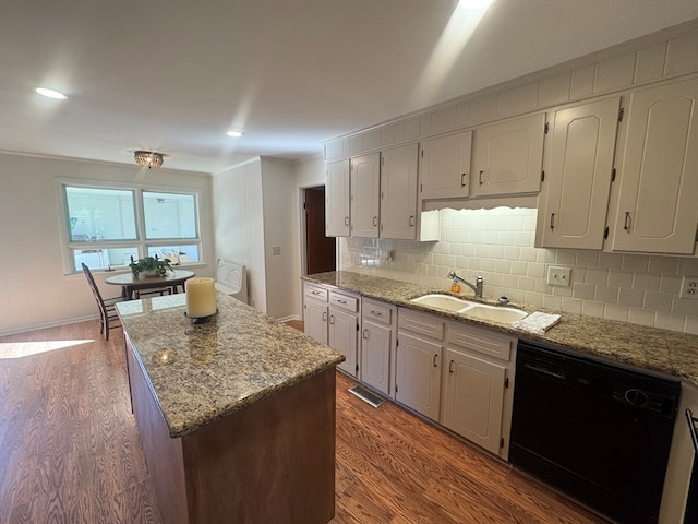 kitchen with dishwasher, dark hardwood / wood-style floors, light stone countertops, and sink