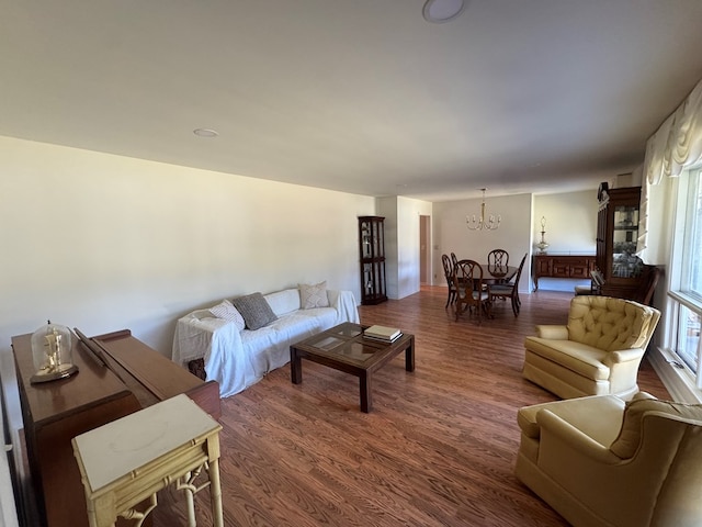 living room with a notable chandelier and dark hardwood / wood-style flooring