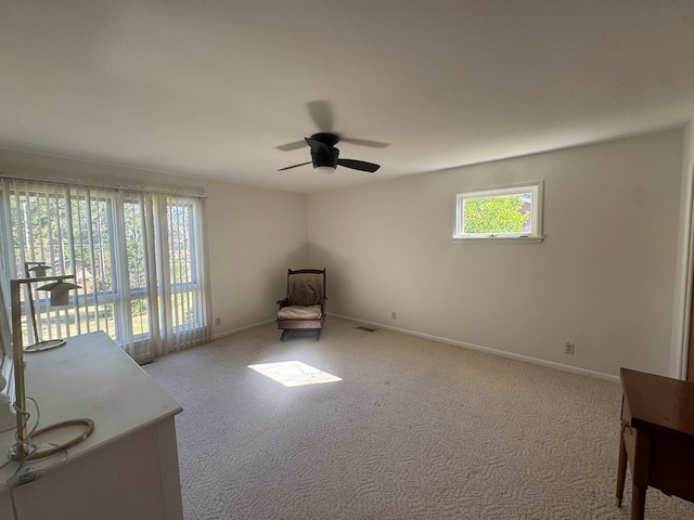 interior space featuring light carpet and ceiling fan