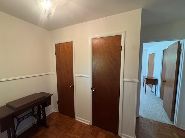 corridor with dark parquet floors and wooden walls