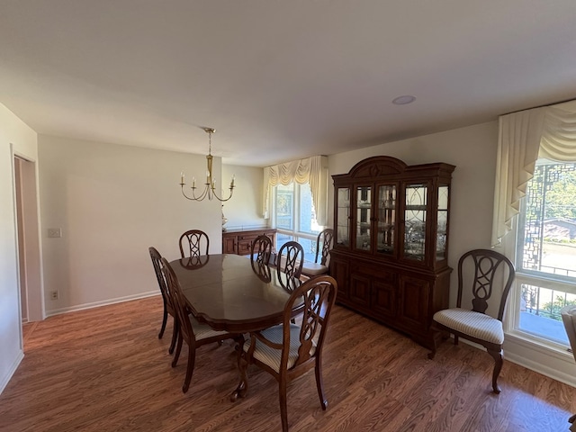 dining room with dark hardwood / wood-style floors and a notable chandelier