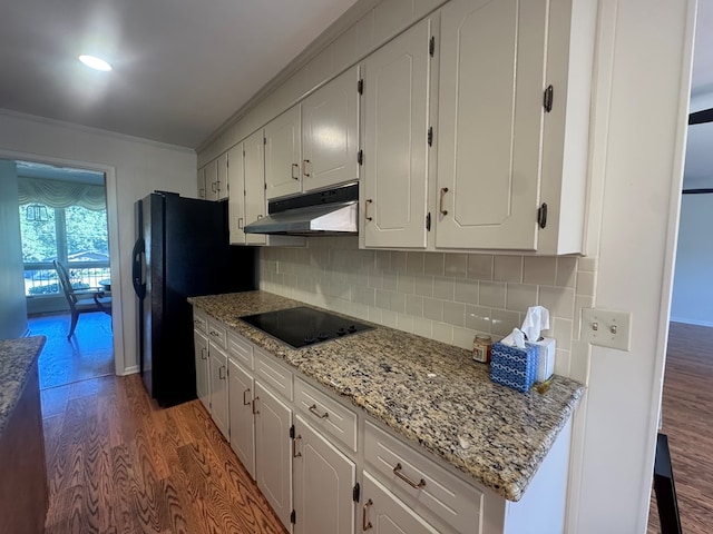 kitchen with white cabinets, black appliances, dark hardwood / wood-style floors, and ornamental molding