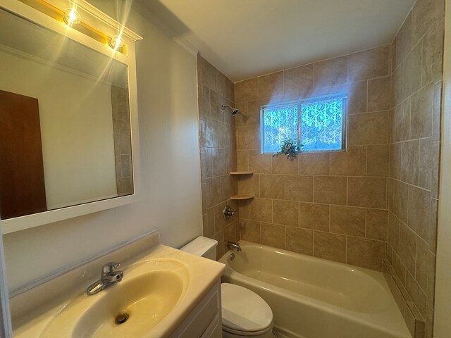 full bathroom featuring vanity, toilet, tiled shower / bath, and ornamental molding