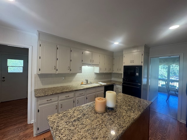 kitchen with dark hardwood / wood-style flooring, black appliances, ornamental molding, and sink