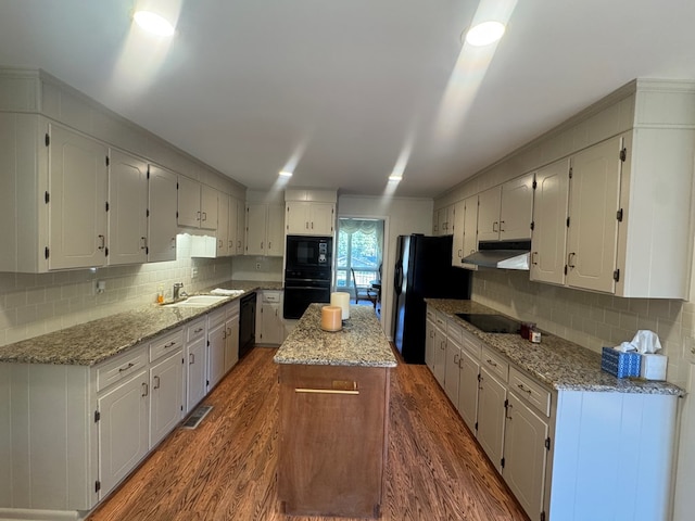 kitchen featuring white cabinetry, sink, dark hardwood / wood-style floors, a kitchen island, and black appliances