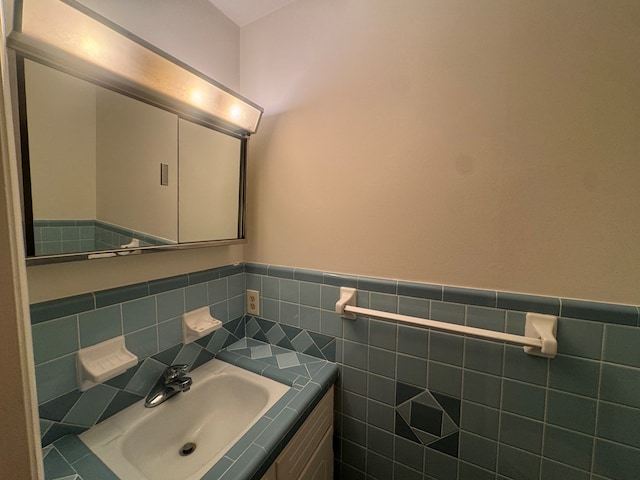 bathroom featuring vanity and tile walls