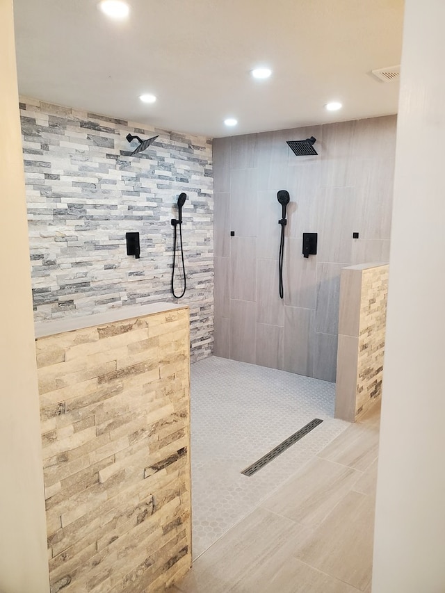 bathroom featuring tiled shower, tile patterned floors, and tile walls