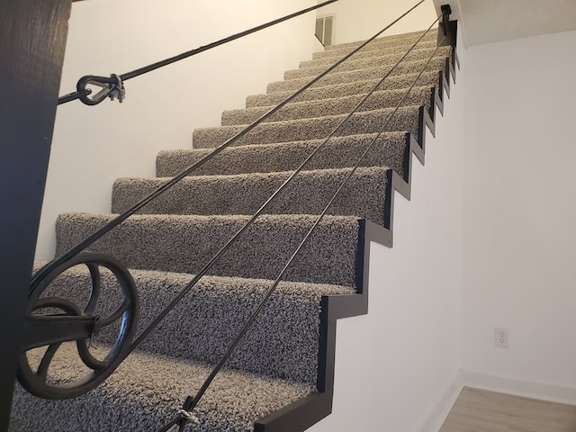 stairway with hardwood / wood-style flooring