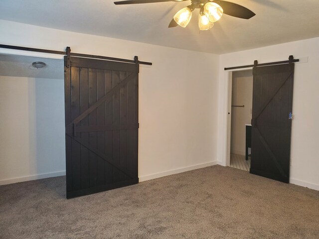 bedroom with carpet flooring, a barn door, and ceiling fan