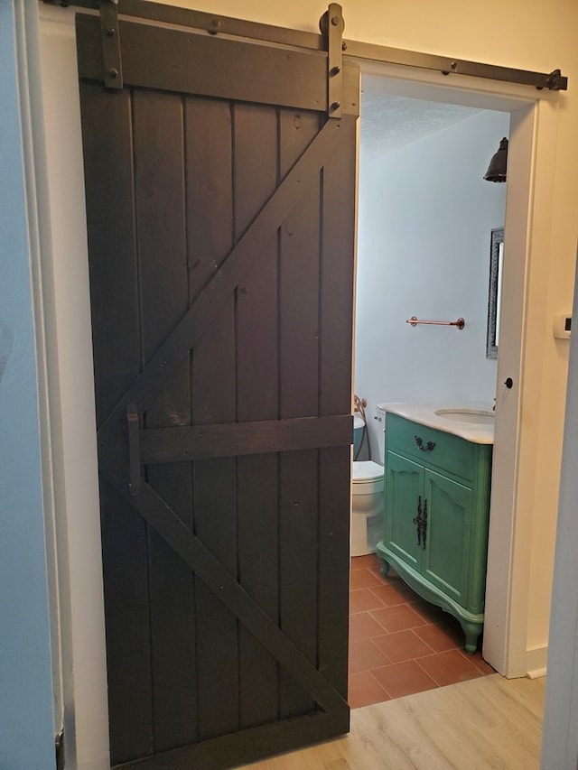 bathroom featuring toilet, vanity, and hardwood / wood-style flooring