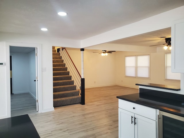 kitchen with wine cooler, white cabinetry, ceiling fan, and light hardwood / wood-style floors