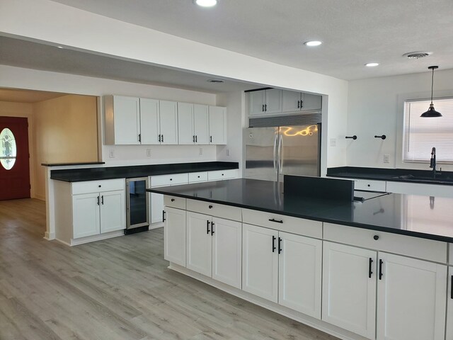 kitchen with white cabinets, pendant lighting, stainless steel built in fridge, and sink