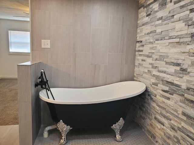 bathroom with a washtub and tile patterned flooring