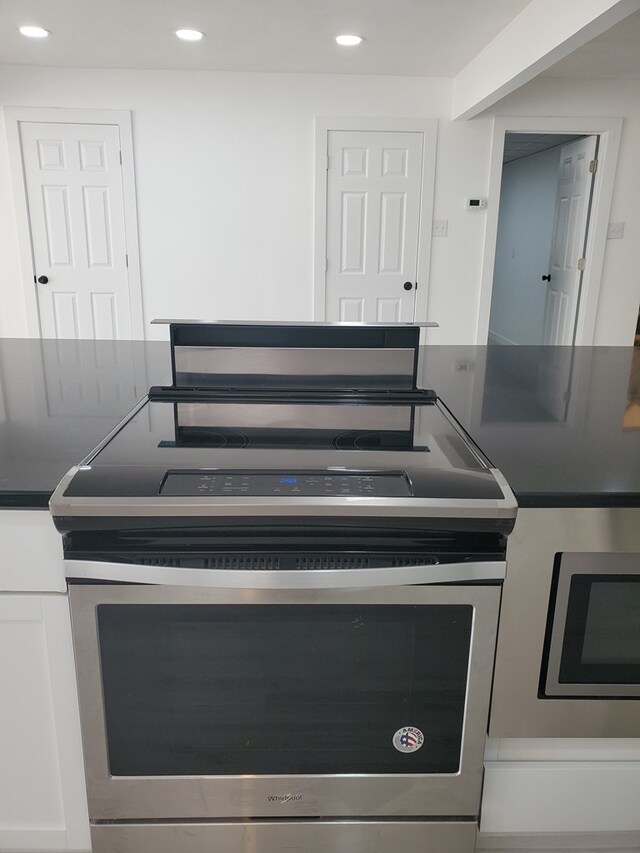 kitchen featuring white cabinetry and stainless steel electric range oven