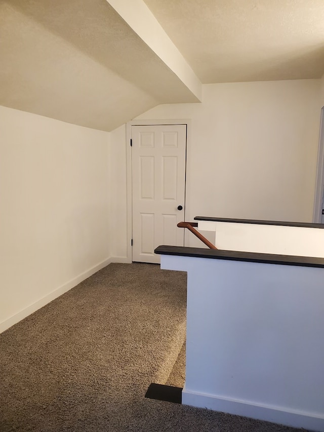 interior space with carpet floors and vaulted ceiling