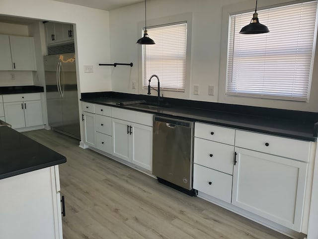 kitchen with appliances with stainless steel finishes, plenty of natural light, pendant lighting, and sink