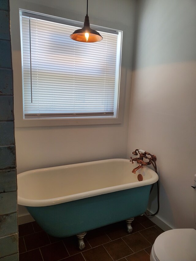 bathroom featuring tile patterned flooring, toilet, and a bathing tub