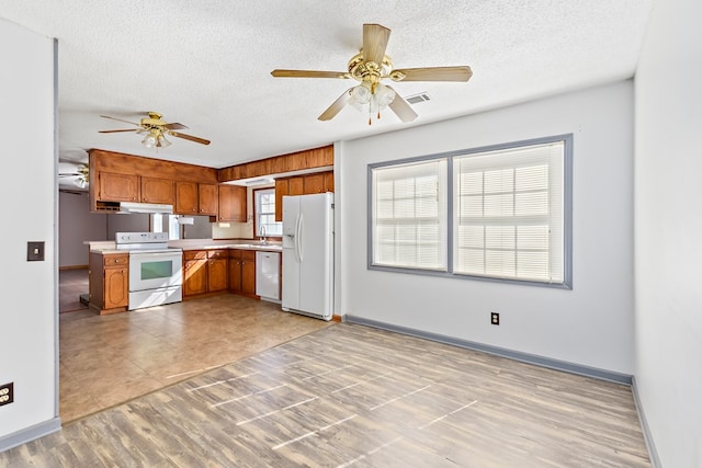 kitchen featuring ceiling fan, white appliances, and a textured ceiling