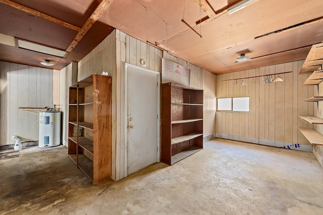 miscellaneous room with concrete flooring and water heater