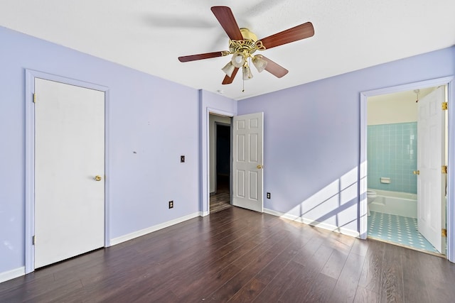 unfurnished bedroom featuring dark hardwood / wood-style flooring, connected bathroom, and ceiling fan