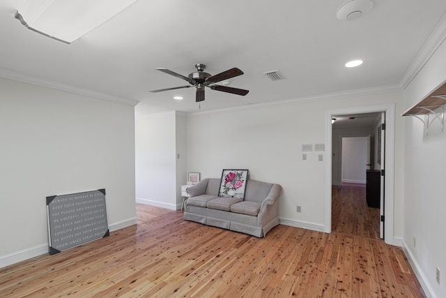 sitting room featuring hardwood / wood-style floors, ceiling fan, and crown molding