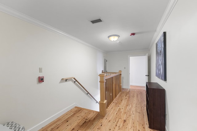 hall with light wood-type flooring and ornamental molding