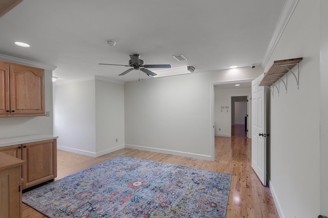 interior space featuring light wood-type flooring, ceiling fan, and crown molding