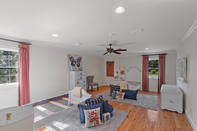 living room with light hardwood / wood-style floors, ceiling fan, and crown molding