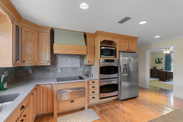 kitchen with light hardwood / wood-style flooring, backsplash, crown molding, appliances with stainless steel finishes, and custom exhaust hood