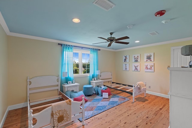 recreation room with ceiling fan, light hardwood / wood-style floors, and ornamental molding