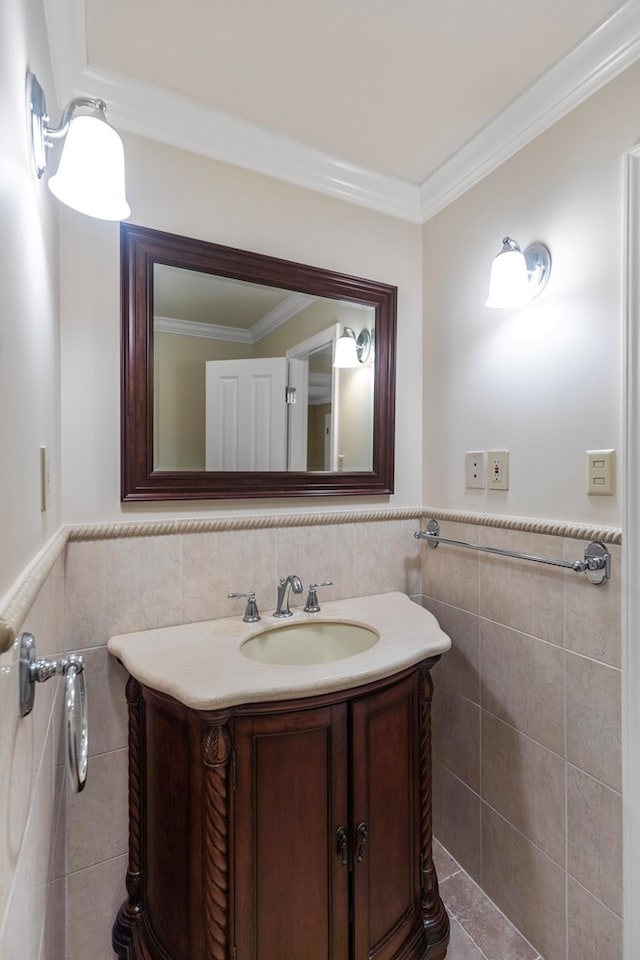 bathroom featuring vanity, ornamental molding, and tile walls