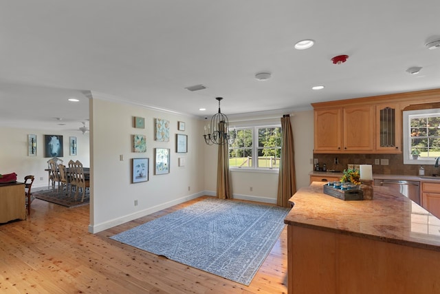 kitchen with dishwasher, a healthy amount of sunlight, light wood-type flooring, and ornamental molding