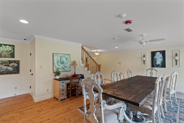 dining area with ceiling fan, ornamental molding, and light wood-type flooring