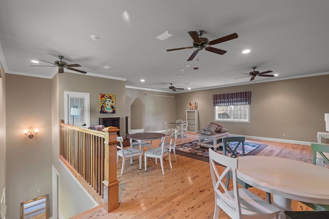 dining space with light hardwood / wood-style floors and crown molding