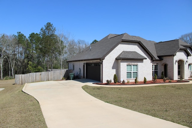 view of front of home with a front lawn, fence, concrete driveway, a shingled roof, and brick siding