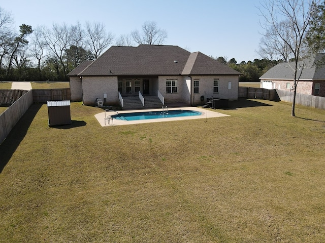 rear view of house featuring a yard, a fenced in pool, a patio, and a fenced backyard