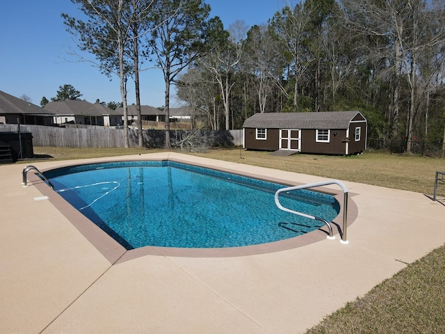 view of swimming pool with an outdoor structure, a yard, a fenced backyard, and a fenced in pool