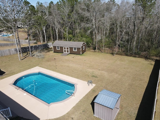 outdoor pool featuring an outdoor structure, a yard, and a fenced backyard