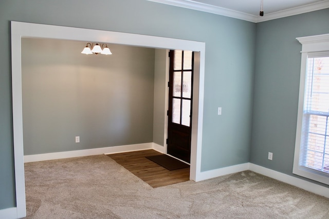 carpeted entrance foyer featuring crown molding and baseboards